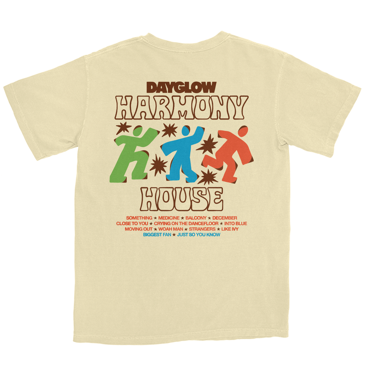 A cream-colored t-shirt featuring a retro-style graphic print of the Dayglow 'Harmony House' logo with colorful figures and text, displayed on a solid white background.