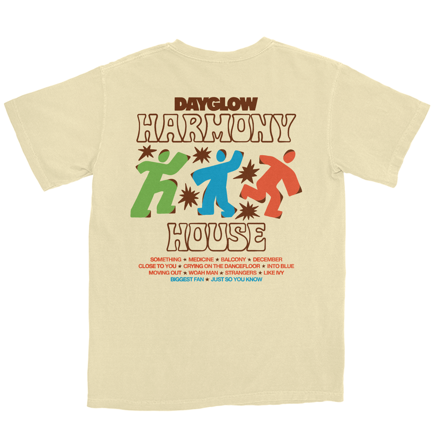 A cream-colored t-shirt featuring a retro-style graphic print of the Dayglow 'Harmony House' logo with colorful figures and text, displayed on a solid white background.